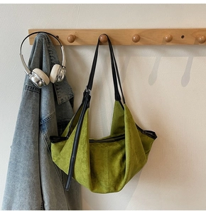 Close-up of green vintage suede tote bag with black leather straps and adjustable buckle