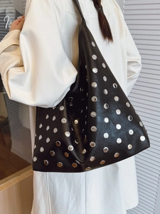 Large black faux leather tote bag with silver metal rivets and casual shoulder strap style