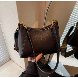 Detail of vintage brown leather bag with retro grain texture and antique gold hardware