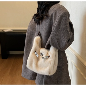 Dettaglio borsa di peluche con chiusura in metallo argento e cinturino in pelle marrone