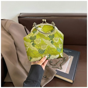 Detailed embroidery of white cranes and green clouds on vintage green brocade purse