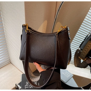 Detail of vintage black hobo bag showing logo embossing and colorful woven strap