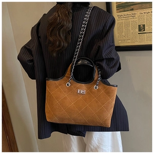 Detail of vintage brown suede tote bag with yellow diamond stitching and metal lock