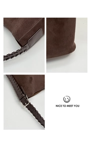 Detail of dark brown suede bucket bag featuring reinforced stitching and adjustable strap