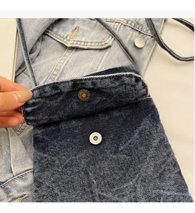 Close-up of dark blue denim bag showing vintage gold snap button and fabric texture