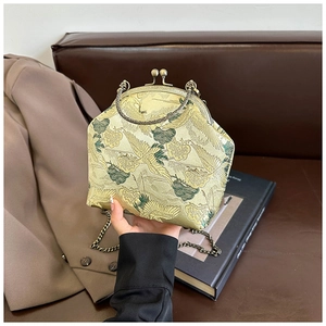 Detail of vintage embroidery handbag with crane pattern and elegant metal chain strap