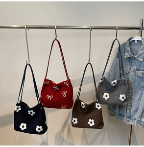 Détails de sacs cabas en feutre de diverses couleurs avec motifs marguerites et nœuds
