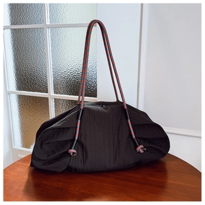 Détail macro du sac cabas plissé noir avec anses en corde rouge bleu et gris