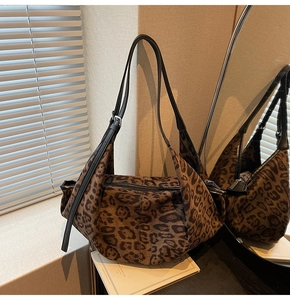 Detail of leopard print crescent bag with black leather strap and silver buckle