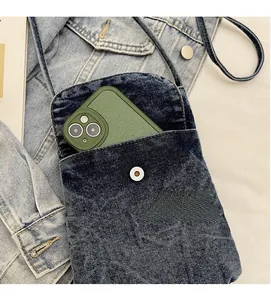 Detail view of durable denim phone bag showing washed fabric and metal buckle pocket