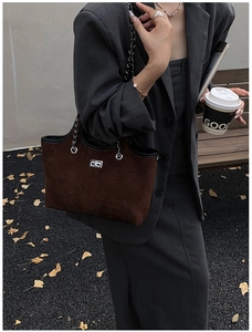 Detail of a brown suede tote bag with diagonal stitching and silver turn-lock clasp