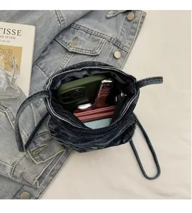 Macro view of blue denim mini crossbody bag interior showing phone and card holder space