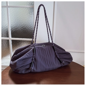 Vue détaillée de la texture plissée et des poignées en corde tressée du grand sac