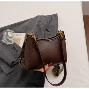 Detail of dark brown PU leather hobo bag with gold hardware and two detachable straps