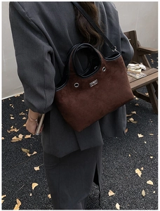 Detail of dark brown faux suede tote with diamond stitching and silver turn-lock closure