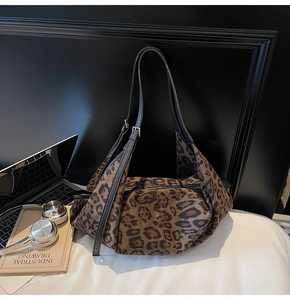 Chic leopard print suede tote bag styled with a laptop and headphones on a white surface