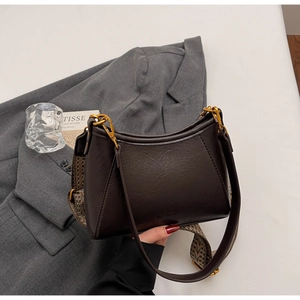Detail of vintage brown leather bag with geometric pattern woven shoulder strap