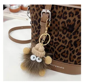 Detail of creative plush leopard bag charm with knit hat and golden lobster clasp