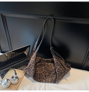 Close-up of leopard print suede tote bag featuring slim black leather straps and texture