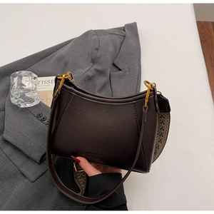 Detail of dark brown leather bucket bag with jacquard strap and gold hardware