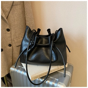 Detailaufnahme einer schwarzen Tragetasche mit Kordelzug auf einem Silberkoffer