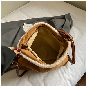 Detail view of large brown suede tote bag with faux shearling trim and spacious interior