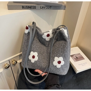 Macro detail of the grey wool tote bag with white floral embroidery and long twin straps