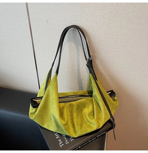 Detail of lime green faux suede tote bag featuring black strap and silver metal buckle