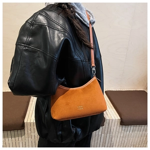 Detail der Vintage-Tasche aus Wildlederimitat in Hellbraun mit Golddruck und Metallhaken