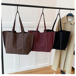 Three leopard print tote bags in dark brown, burgundy, and black with silver studs