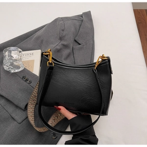 Detail of black pebbled leather hobo bag with ethnic woven strap and vintage metal zipper
