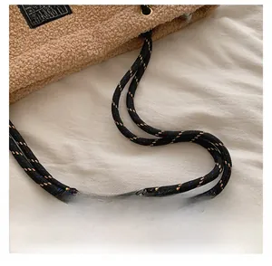 Gros plan d'un sac cabas en peluche marron avec anse en corde tressée multicolore