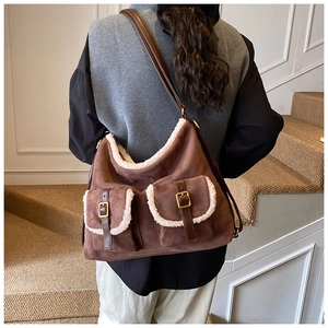 Detail of vintage suede shoulder bag with faux shearling trim and dual front pockets