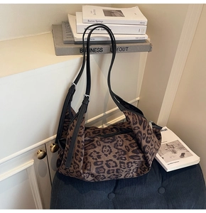 Detail of leopard print tote bag featuring adjustable shoulder straps with silver buckles