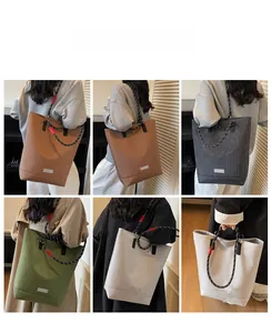 Multiple colors of large plaid canvas tote bags with unique braided shoulder straps