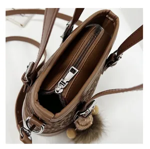 Detailed close-up of the smooth metal zipper closure on leopard print bucket bag