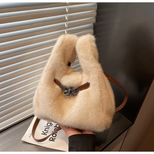 Dettaglio della borsa in peluche con cinturini in pelle marrone e chiusura in argento