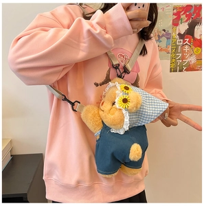 Detailed close-up of cute plush bear crossbody bag with denim overalls and floral bandana