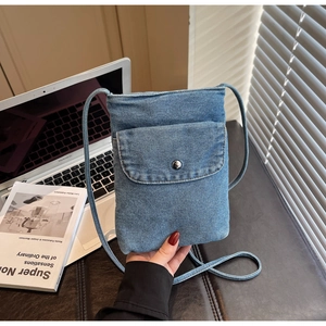 Close-up of light blue denim phone crossbody bag with front pocket and metal snap button