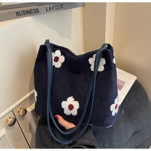 Detail of the navy blue plush tote bag with white flower embroidery and PU leather strap
