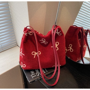 Close-up of red wool tote bag with white bow embroidery and red leather straps