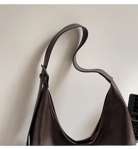 Detailed close-up of dark brown PU leather hobo bag with adjustable buckle strap