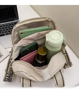 Vue intérieure montrant les compartiments spacieux du sac en nylon blanc cassé