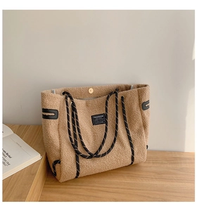 Détail du grand sac cabas en polaire marron avec étiquette FASHION INSTINCT et anses tissées