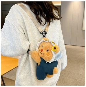 Detail showing the sunflower hat and blue denim overalls on the plush bear bag