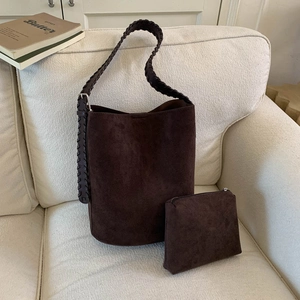 Detail of dark brown faux suede bucket bag with its matching zipper pouch and woven strap