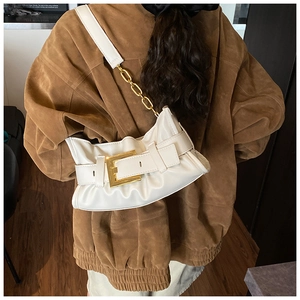 Detailed view of white pleated cloud bag with stylish large gold buckle and chain strap