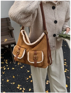 Detail of camel suede tote bag with white faux fur trim and vintage buckle pockets