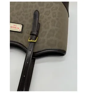 Dettaglio della borsa tote leopardata con finiture dorate e tracolla in pelle marrone