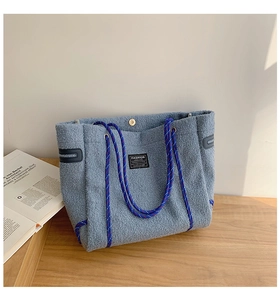 Détail du sac cabas en polaire bleue avec patch fashion et poignées en corde tressée